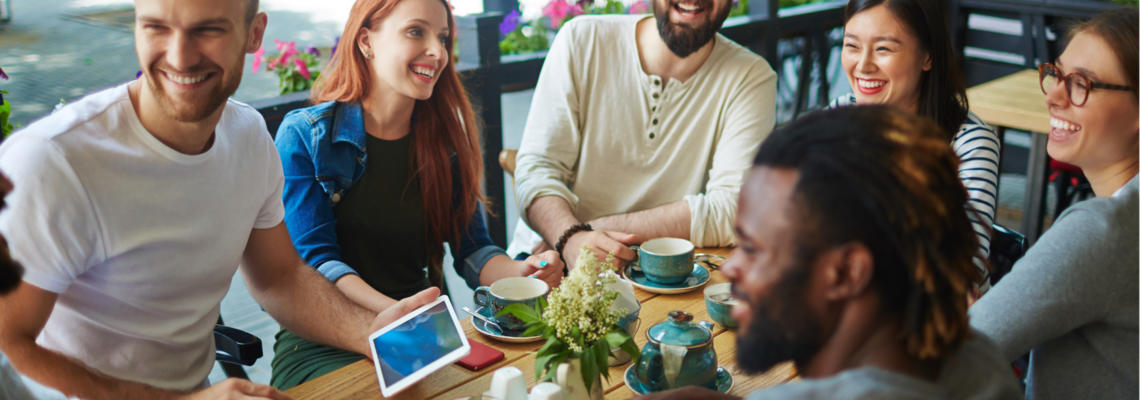 Abbildung viele Personen unterhalten sich im Café am Tisch und trinken Café 